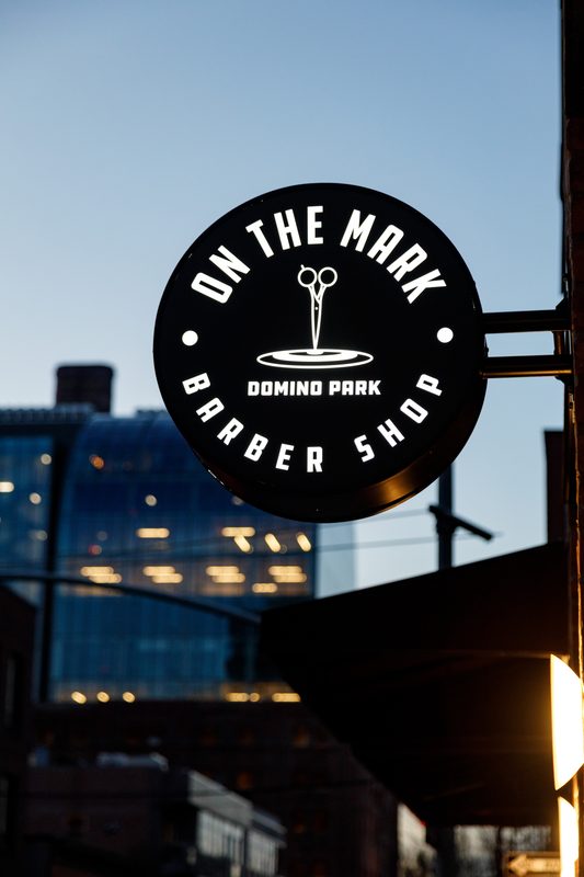 The round On the Mark sign at dusk