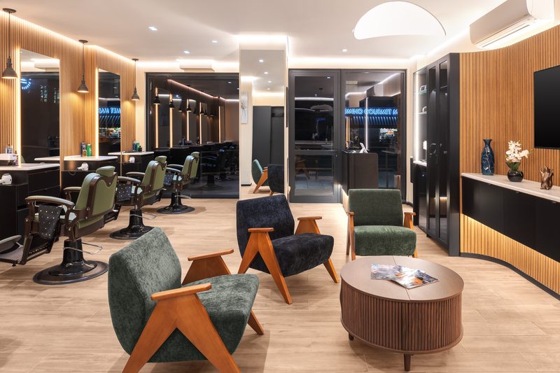 The waiting area with olive chairs and a wood slat wall