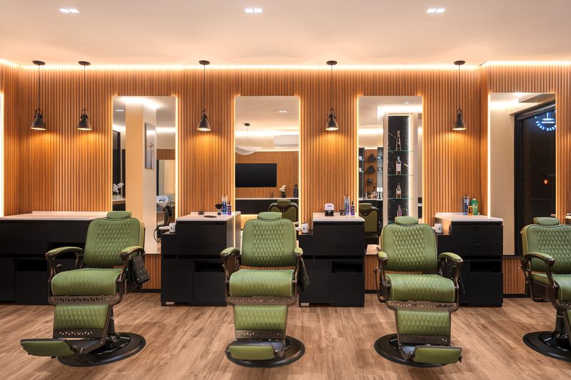 The row of olive barber chairs and mirrors inside On the Mark